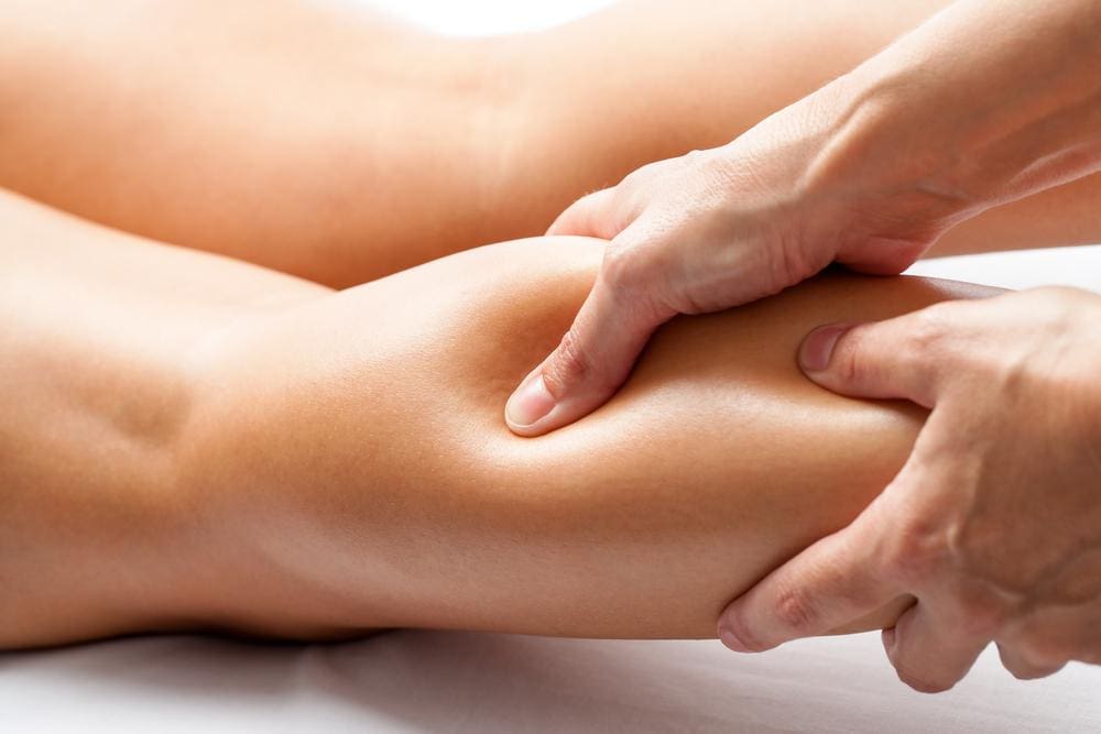 Chiropractor treating lower legs of a patient. 