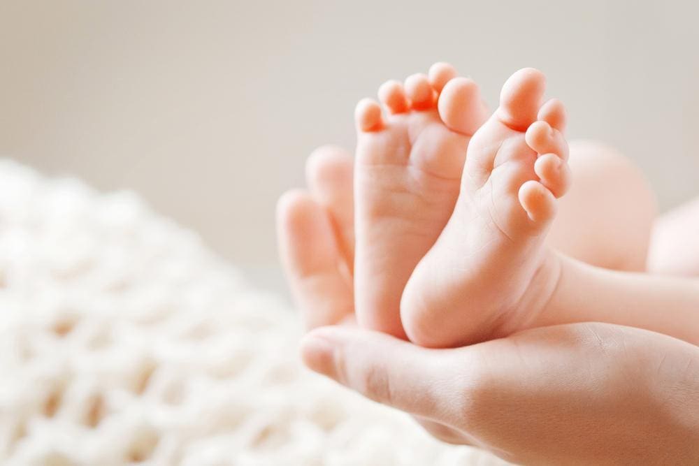 Mother holding her baby's feet,