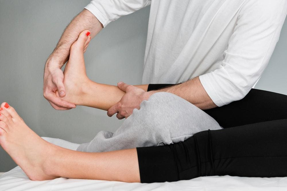 Chiropractor adjusting a female patient's foot.