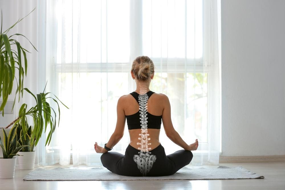 Young woman meditating with proper spine in alignment.
