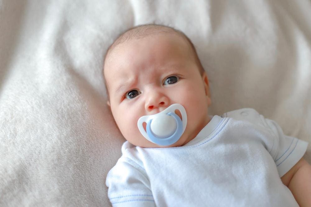 Infant sucking on a pacifier.
