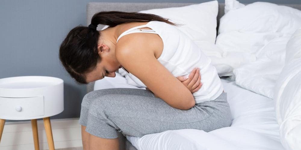 Woman experiencing stomach pain from Crohn's Disease.