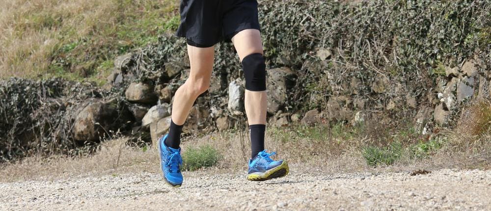 Runner jogging with a knee brace.