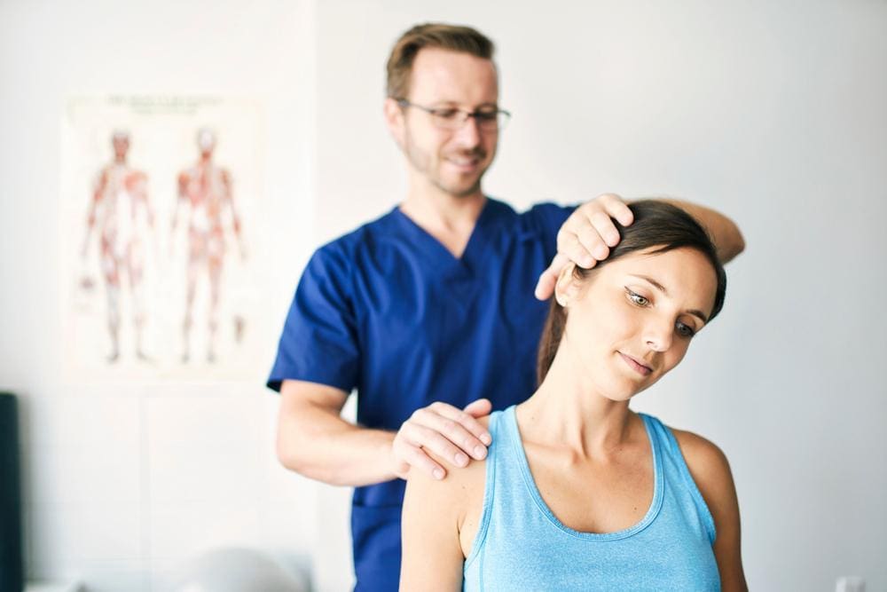 Chiropractor adjusting young woman's neck.