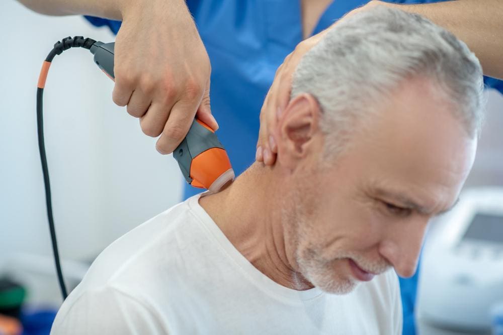 Senior man having ultrasound of his neck.