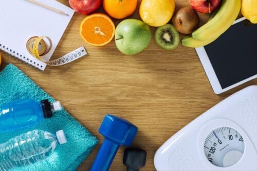 Healthy foods, exercise equipment, and a scale.