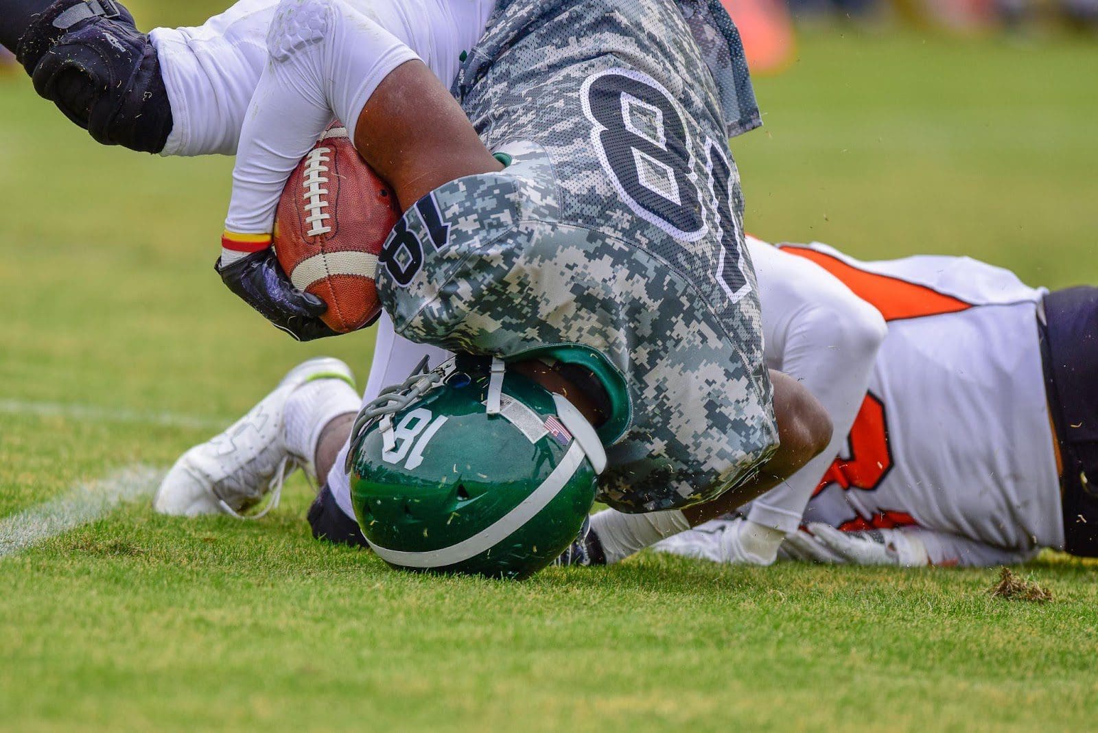 High school football player gets tackled, lands on his shoulder.