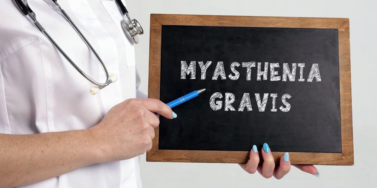Healthcare worker holding a chalkboard that reads "Myasthenia Gravis".